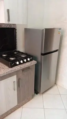 a kitchen with a stove and a stainless steel refrigerator at appartamento lalla Rita short-term rent in Marrakech