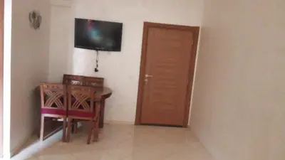 a room with a table and a television and a door at appartamento lalla Rita short-term rent in Marrakech