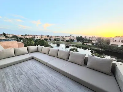 a white couch sitting on top of a roof at Penthouse Marrakech Village avec vue Panoramique sur le Lac in Marrakech
