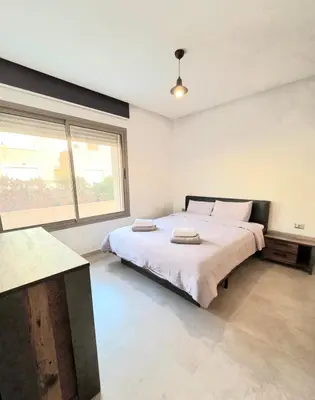 a bedroom with a large bed and a large window at Penthouse Marrakech Village avec vue Panoramique sur le Lac in Marrakech