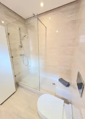 a bathroom with a shower and a toilet and a glass shower stall at Penthouse Marrakech Village avec vue Panoramique sur le Lac in Marrakech