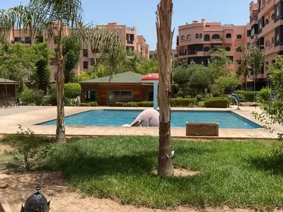 a man laying on the ground next to a swimming pool at Résidence Soleil Vue Piscine in Marrakech
