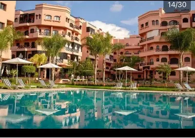 a large swimming pool in front of a large building at Résidence Soleil Vue Piscine in Marrakech