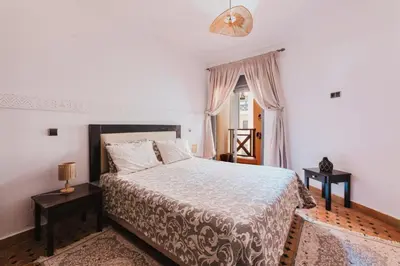 a bedroom with a large bed and a window at Cocon au calme Residence Piscine Marrakech in Marrakech
