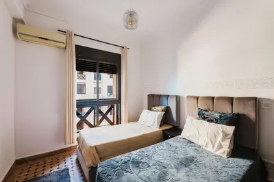 a bedroom with two beds and a window at Cocon au calme Residence Piscine Marrakech in Marrakech