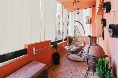 a balcony with a bench and a chair and a window at Cocon au calme Residence Piscine Marrakech in Marrakech