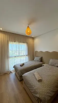 a bedroom with two beds and a window at Magnifique appartement in Marrakech