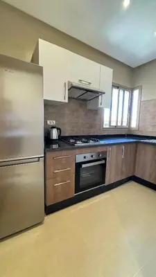a kitchen with a refrigerator and a stove top oven at Magnifique appartement in Marrakech