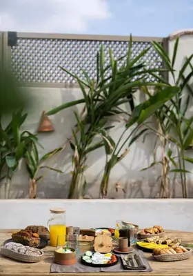 a table topped with breakfast foods and orange juice at Riad Kasbah Lover Swimming pool breakfast included in Marrakech
