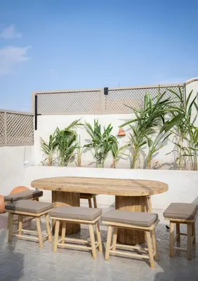 a wooden table and benches and a table and chairs at Riad Kasbah Lover Swimming pool breakfast included in Marrakech