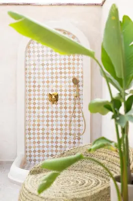 a bathroom with a shower with a gold object on the wall at Riad Kasbah Lover Swimming pool breakfast included in Marrakech