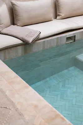 a couch sitting next to a swimming pool at Riad Kasbah Lover Swimming pool breakfast included in Marrakech