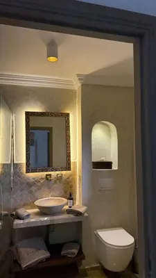 a bathroom with a sink and a toilet and a mirror at Riad Kasbah Lover Swimming pool breakfast included in Marrakech