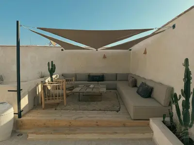 a patio with a couch and a table and cactus at Riad Kasbah Lover Swimming pool breakfast included in Marrakech
