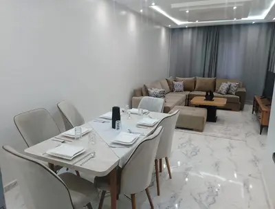 a room with a table and chairs and a couch at Bright Apartment, 10 minutes from Gueliz and 7 minutes from Majorelle Garden in Marrakech