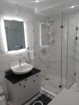 a white bathroom with a sink and a shower at Bright Apartment, 10 minutes from Gueliz and 7 minutes from Majorelle Garden in Marrakech