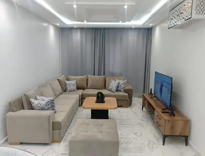 a living room with a couch and a tv at Bright Apartment, 10 minutes from Gueliz and 7 minutes from Majorelle Garden in Marrakech