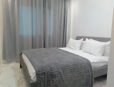 a bedroom with a bed with white sheets and pillows at Bright Apartment, 10 minutes from Gueliz and 7 minutes from Majorelle Garden in Marrakech