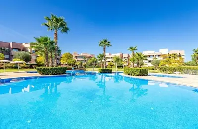 a large blue swimming pool with palm trees and buildings at Modern 3BR Luxury Prestigia Golf in Marrakech