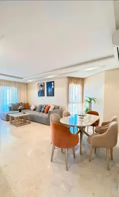 a living room with a couch and a table and chairs at Modern 3BR Luxury Prestigia Golf in Marrakech