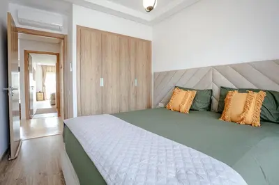 a bedroom with a large bed with orange and green pillows at Noria Marrakech in Marrakech