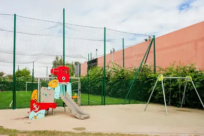 a playground with a slide in front of a fence at Noria Marrakech in Marrakech