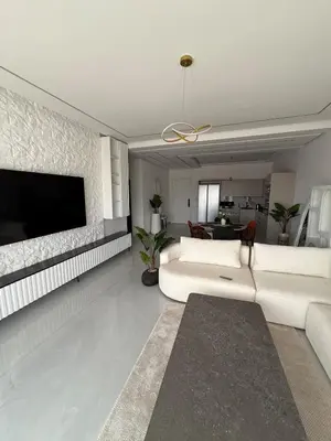a living room with a white couch and a tv at Modern Apartment in Jnane Gueliz in Marrakech