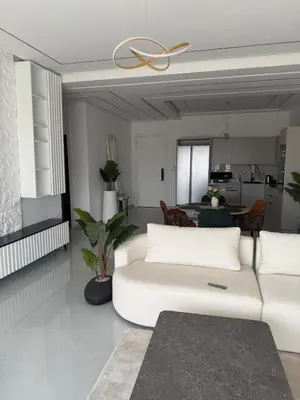 a living room with a white couch and a kitchen at Modern Apartment in Jnane Gueliz in Marrakech