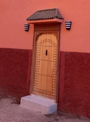 a wooden door in the side of a building at Riad Douiria MiLa Luxury Private 2 to 4 people in Marrakech