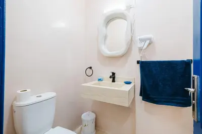 a bathroom with a white toilet and a blue towel at Cozy Mykonos 2BR Apartment in Marrakech