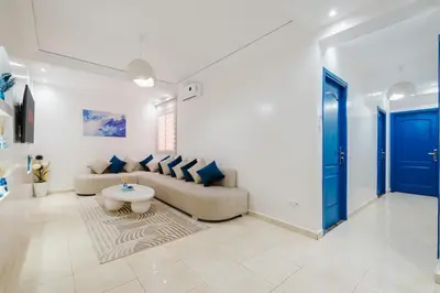 a living room with a couch and a table at Cozy Mykonos 2BR Apartment in Marrakech