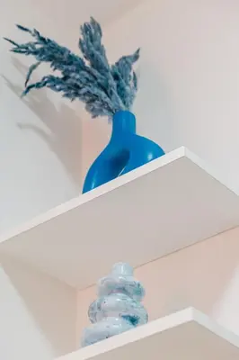 a blue vase sitting on a white shelf at Cozy Mykonos 2BR Apartment in Marrakech