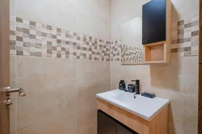 a bathroom with a sink and a tiled wall at Central Luxury Gem marrakech 3BR in Marrakech