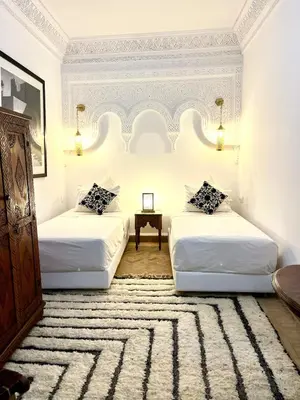 a bedroom with two beds and a table at Entire Boutique Riad with 5star Hospitality Breakfast included in Marrakech