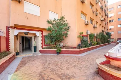 an empty courtyard of a building with a tree at Cocon Urbain centre-ville et confort in Marrakech