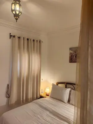 a bedroom with a bed with white sheets and a window at Riad Palm Oasis Marrakech in Marrakech