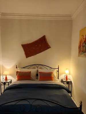 a bedroom with a bed with two orange pillows at Riad Palm Oasis Marrakech in Marrakech
