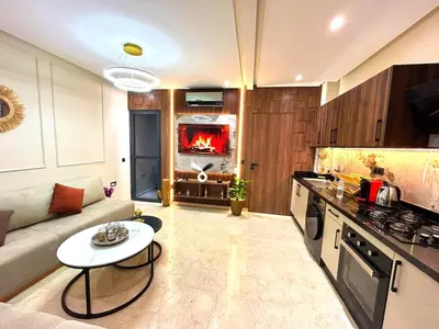 a living room with a couch and a table in a kitchen at Central Victor Hugo Studio near Gueliz Wi-Fi in Marrakech