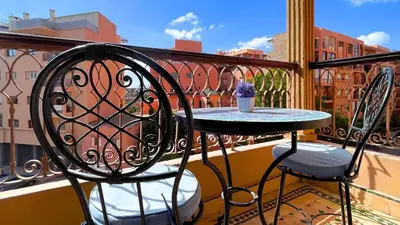 a small table and two chairs on a balcony at Très belle appartement à Gueliz in Marrakech