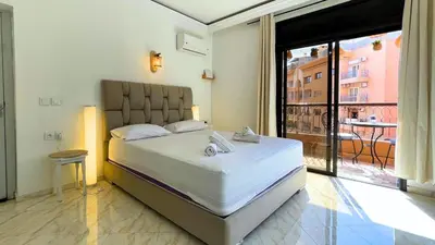 a bedroom with a large bed and a large window at Très belle appartement à Gueliz in Marrakech
