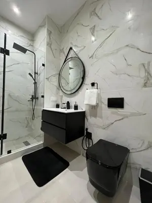 a bathroom with a toilet and a sink and a mirror at Palmeraie Cozy Apartment in Marrakech