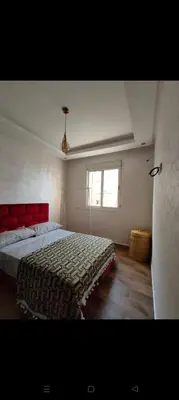 a bedroom with a bed with a red headboard and a window at Casa della calma in Marrakech