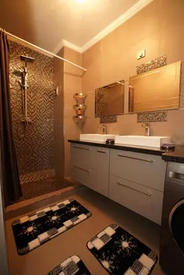 a bathroom with a sink and a shower with mats at Superbe Appartement 3 pieces à Majorelle in Marrakech