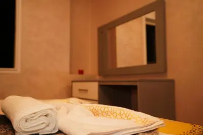 a bathroom with a bed with towels and a mirror at Superbe Appartement 3 pieces à Majorelle in Marrakech