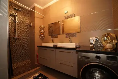 a bathroom with a sink and a washing machine at Superbe Appartement 3 pieces à Majorelle in Marrakech