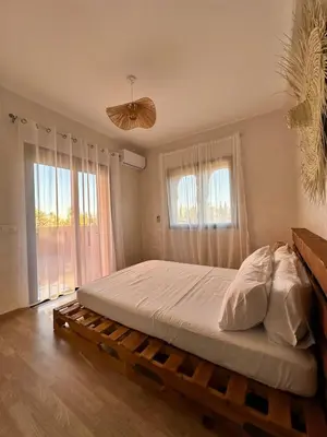a bedroom with a bed on a wooden platform with windows at Serenity Loft in Marrakech