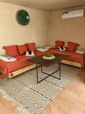 a living room with a red couch and a table at Dar Aji, votre maison d'architecte privatisée en médina in Marrakech