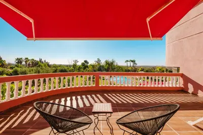 two chairs on a balcony with a red roof at Villa Targaït - Luxury villa in Marrakech bliss in Marrakech