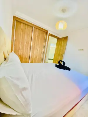 a white bed with a pair of black shoes on it at duplex 3 Rom with spacious Guéliz victor hugo spacieuse in Marrakech