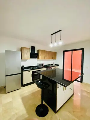 a kitchen with a black counter and a refrigerator at duplex 3 Rom with spacious Guéliz victor hugo spacieuse in Marrakech